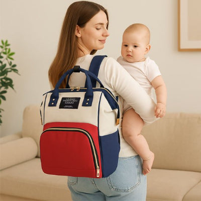 Sac a langer au dos maman porte son bebe dans les bras