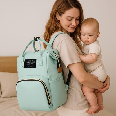 Sac a langer vert maman porte au dos avec bebe dans les bras